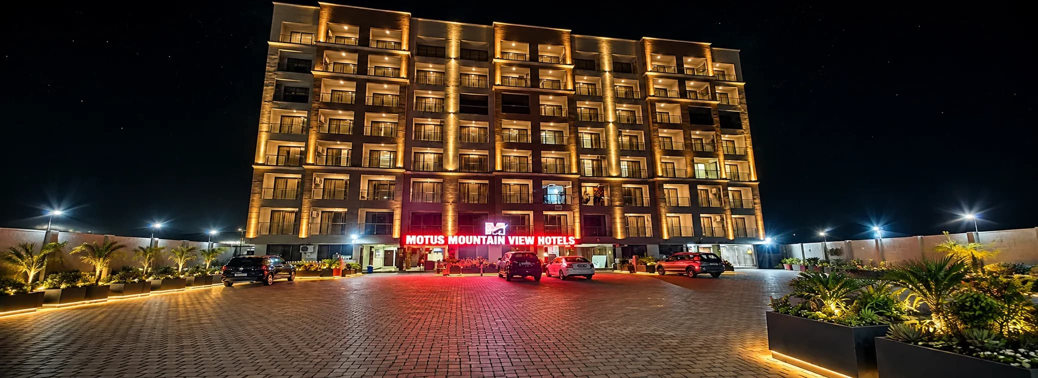 Motus Mountain View Hotels lit at night across the courtyard