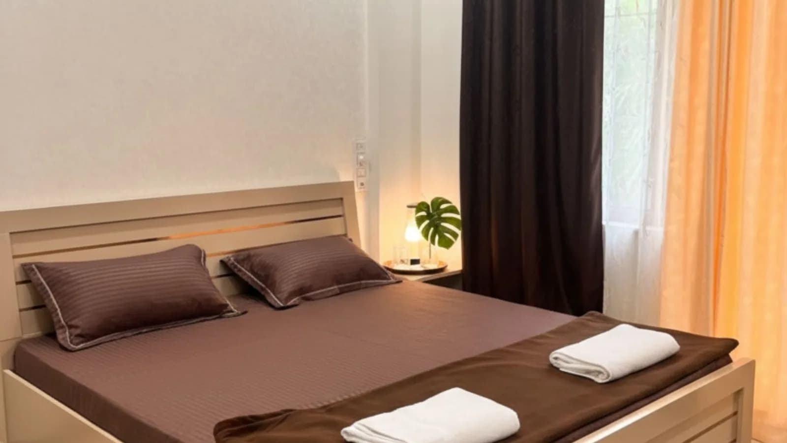 Deluxe room with a king bed, layered linens and warm bedside lighting
