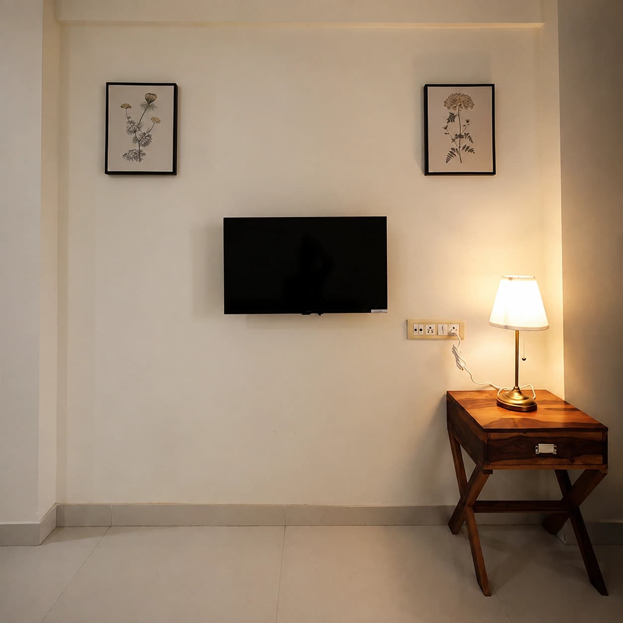 Deluxe Double Room: Sitting corner with wall-mounted TV and warm lamp light